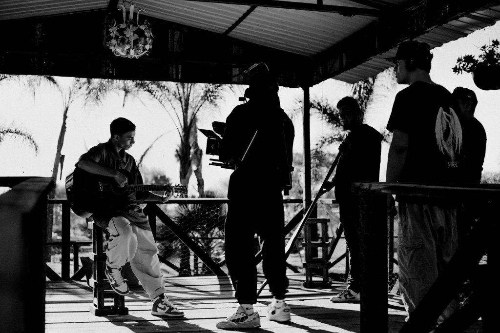 equipo de producción grabando un músico tocando guitarra